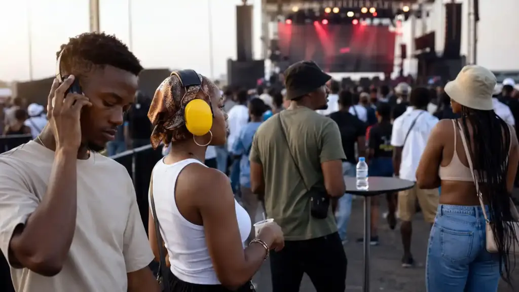 Young adults practicing safer listening by reducing volume, increasing distance, taking breaks, and using hearing protection, which are ways of protecting against noise pollution.